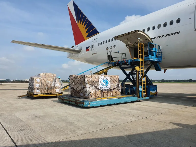Cargo boxes being loaded onto a commercial airplane, representing an international air freight purchase order shipment