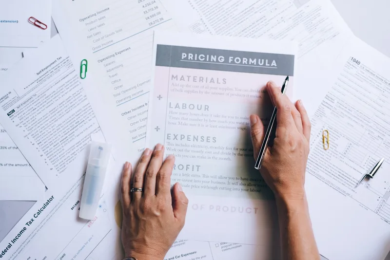 Business documents and pricing spreadsheet showing formula calculations for stock management
