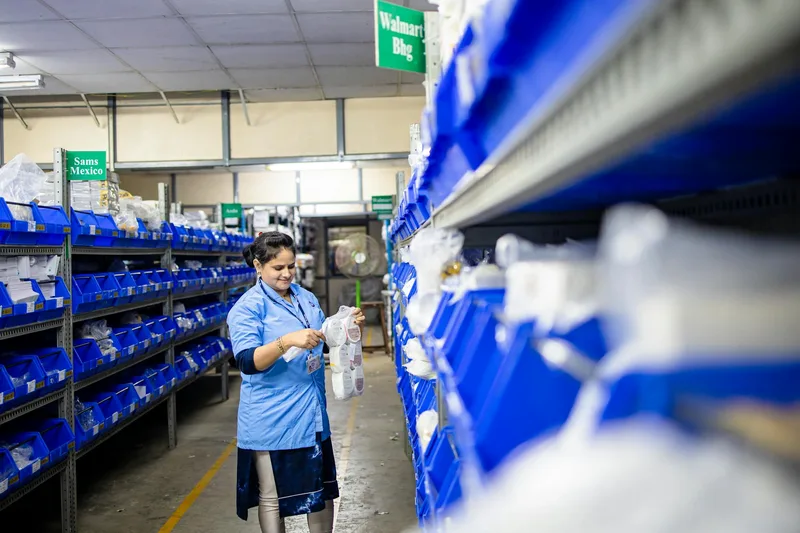 Warehouse worker sorting inventory on shelves in an organized ecommerce storage facility
