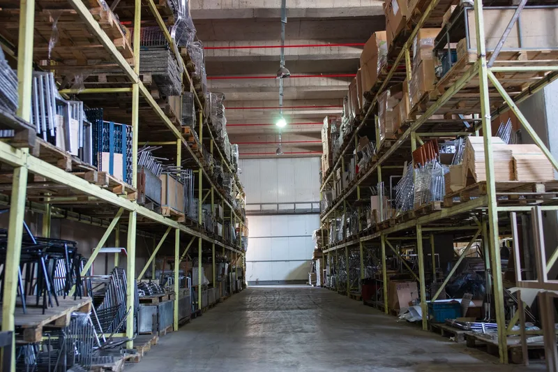 Wide warehouse aisle lined with tall metal shelving loaded with stock