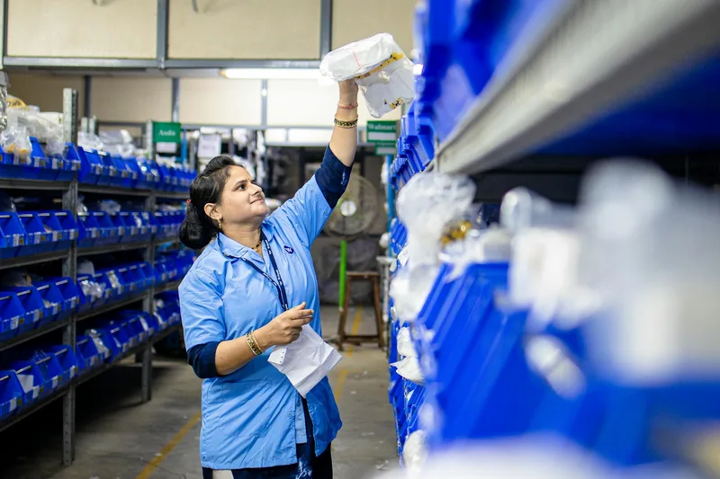 Warehouse worker picking orders from organised shelving following a structured WMS warehouse management system pick list workflow